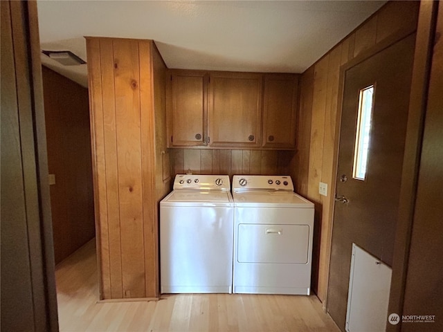 1411 300th Pl, Ocean Park, WA 98640 - washroom with washer and dryer, light hardwood / wood-style floors, wooden walls, and cabinets
