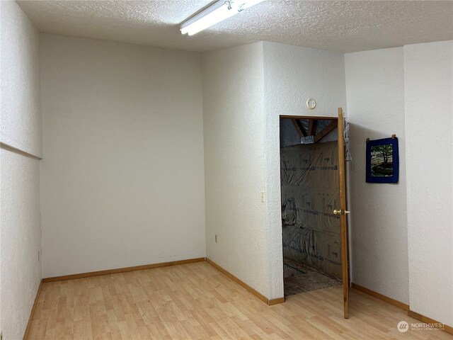 1411 300th Pl, Ocean Park, WA 98640 - unfurnished bedroom with a textured ceiling and light hardwood / wood-style flooring