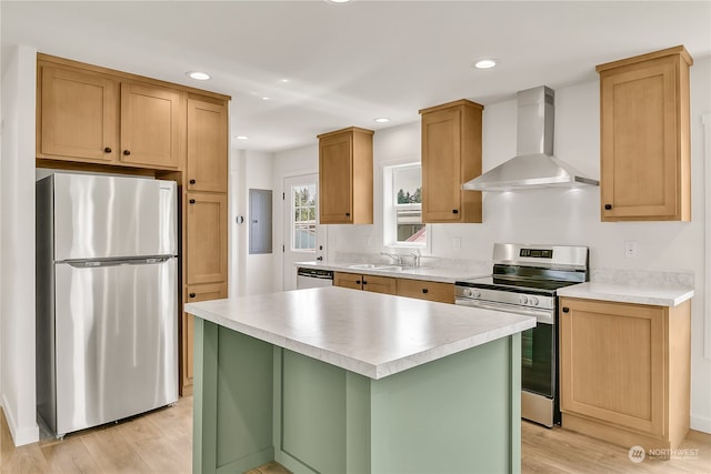 kitchen featuring light hardwood / wood-style floors, stainless steel appliances, a kitchen island, and wall chimney range hood