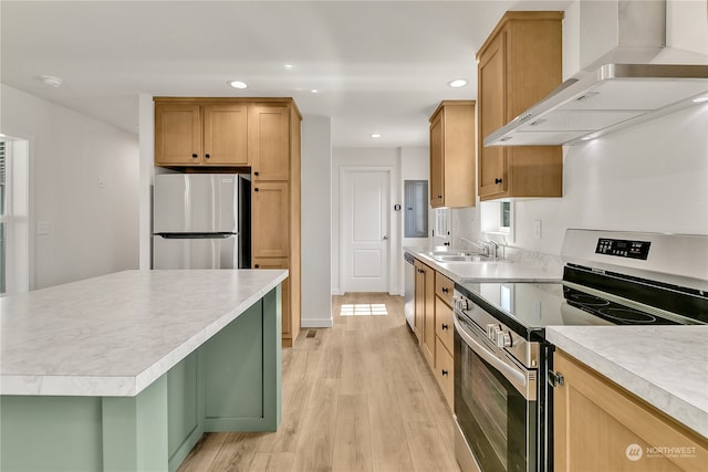 kitchen featuring wall chimney range hood, light hardwood / wood-style floors, electric panel, sink, and stainless steel appliances