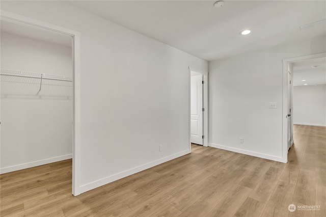 unfurnished bedroom with light wood-type flooring and a closet