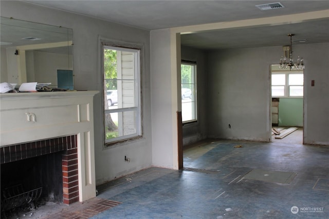 unfurnished living room with a chandelier and a fireplace