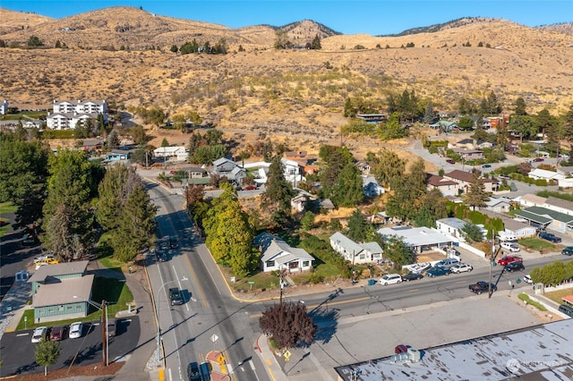 aerial overview of property's location with a mountainous background and nearby suburban area