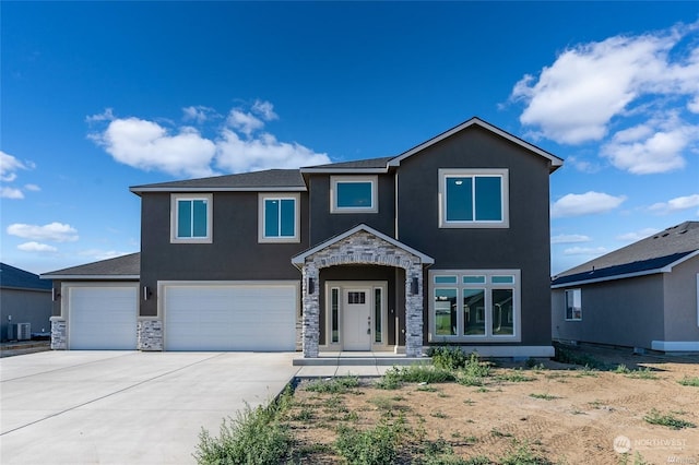 traditional-style home featuring a garage, stone siding, concrete driveway, and stucco siding