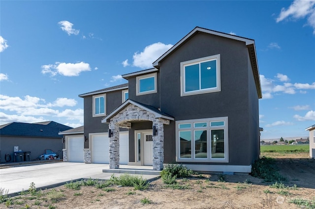 view of front of property with a garage, stone siding, driveway, and stucco siding