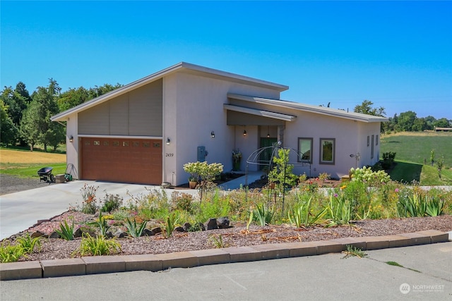 view of front of home featuring concrete driveway, an attached garage, and stucco siding