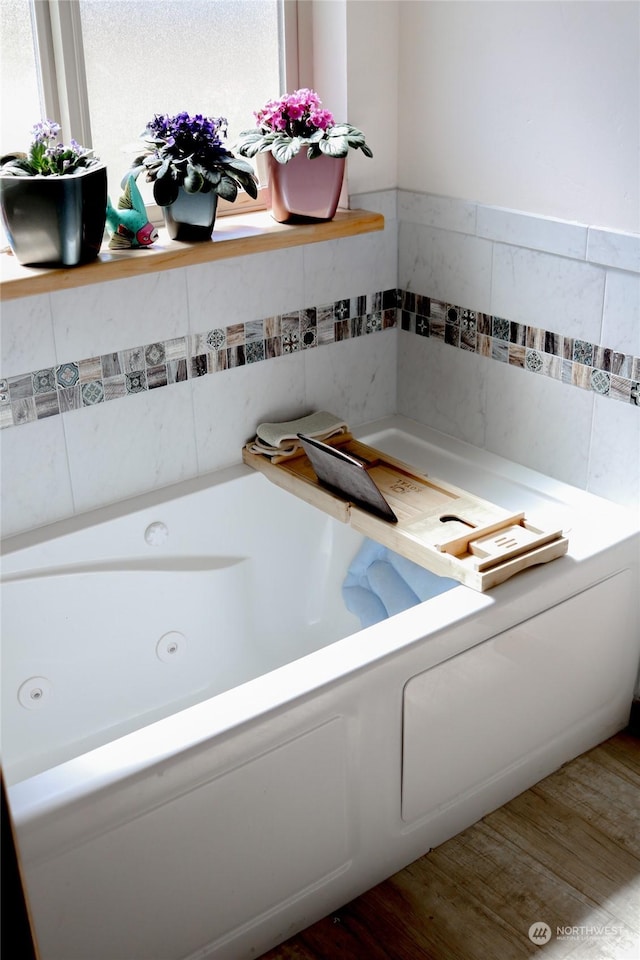 full bathroom with a jetted tub and wood finished floors