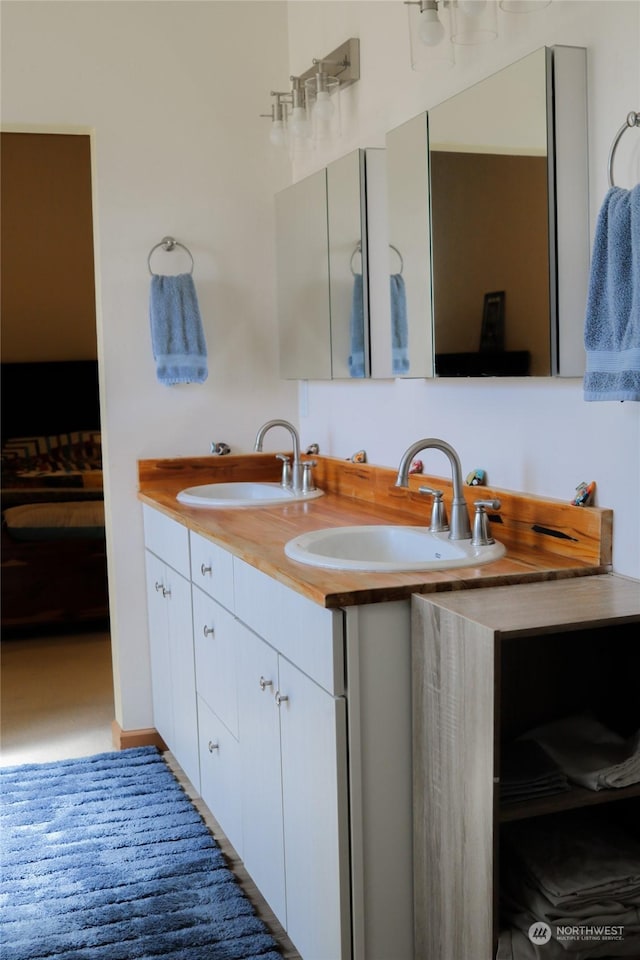 full bathroom featuring a sink, connected bathroom, and double vanity