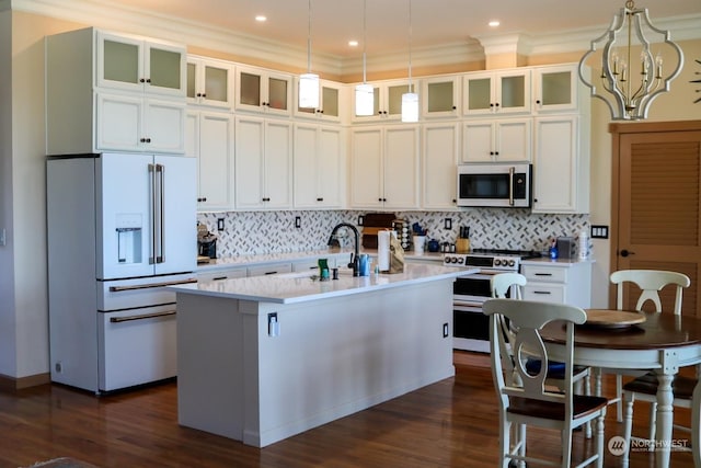 kitchen with high end white fridge, a center island with sink, light countertops, range with two ovens, and dark wood-style floors