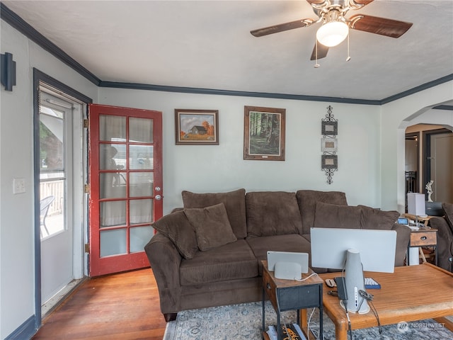 living room with ceiling fan, wood-type flooring, and ornamental molding