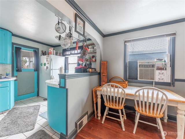 dining room featuring light wood-type flooring, cooling unit, and crown molding