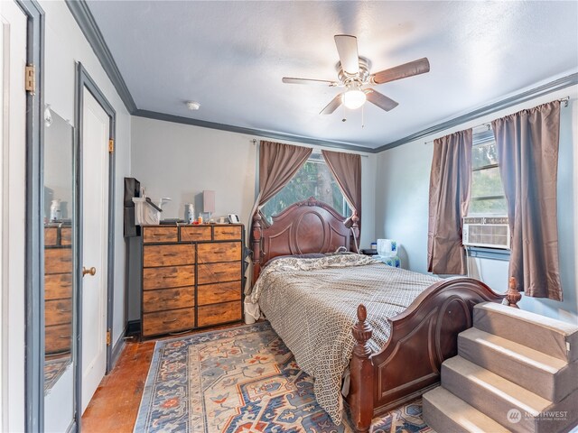 bedroom with ceiling fan, multiple windows, and crown molding