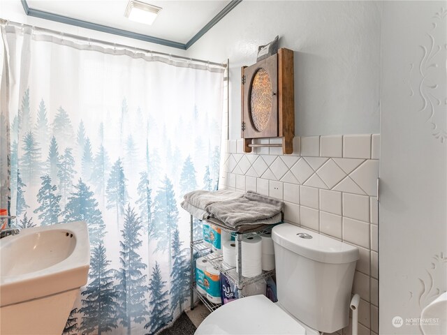 bathroom with sink, decorative backsplash, curtained shower, tile walls, and toilet