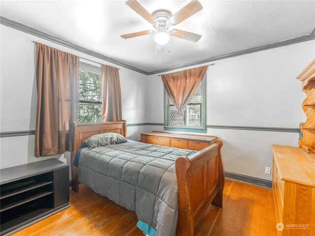 bedroom featuring light hardwood / wood-style floors, ornamental molding, and ceiling fan