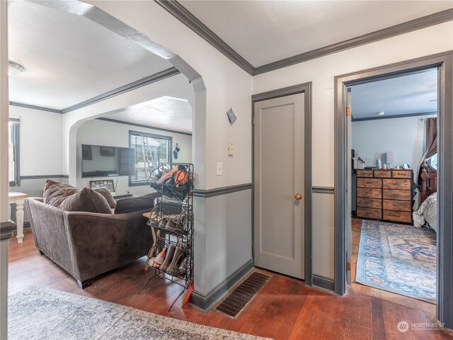 interior space featuring crown molding and dark wood-type flooring