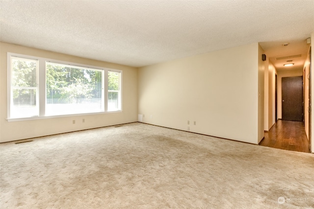 spare room with a textured ceiling and hardwood / wood-style flooring