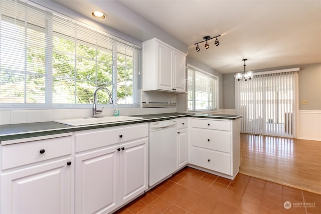 kitchen with white dishwasher, white cabinetry, sink, wood-type flooring, and pendant lighting