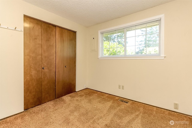 17407 36th Ave E, Tacoma, WA 98446 - unfurnished bedroom featuring visible vents, a closet, carpet, and a textured ceiling