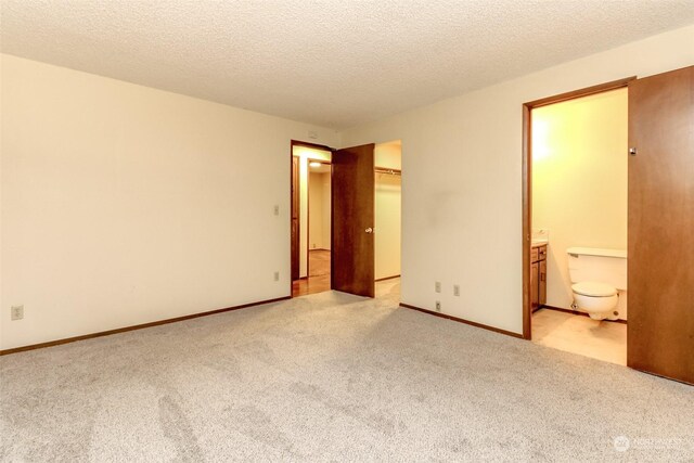 17407 36th Ave E, Tacoma, WA 98446 - unfurnished bedroom featuring a closet, ensuite bath, light colored carpet, and a textured ceiling