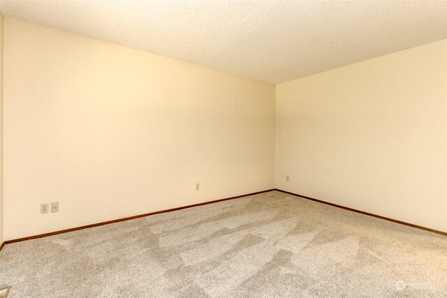 empty room with a textured ceiling and carpet