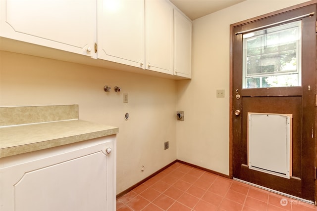 laundry area featuring light tile patterned floors, hookup for an electric dryer, and cabinets