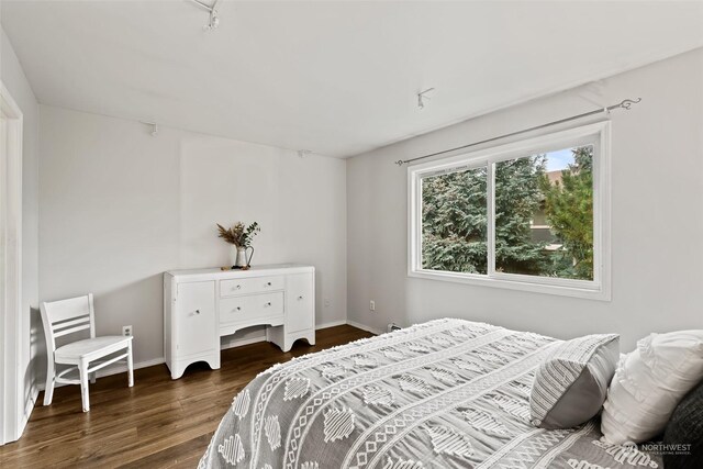 bedroom with baseboards and wood finished floors