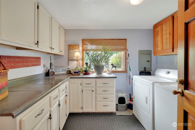 laundry area featuring electric panel, cabinet space, and washer and clothes dryer