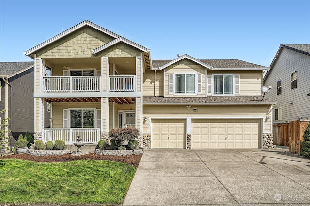 view of front facade featuring a balcony, a garage, and a front yard