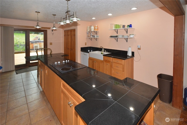 kitchen featuring black electric stovetop, hanging light fixtures, a center island, and a textured ceiling