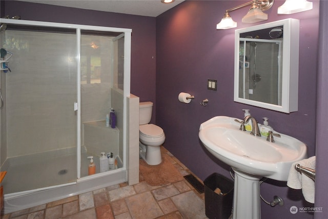 bathroom featuring walk in shower, toilet, and tile patterned floors