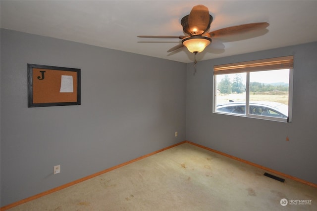 carpeted empty room featuring ceiling fan