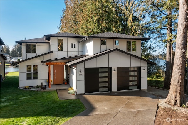 view of front facade with a garage, a front lawn, and a water view