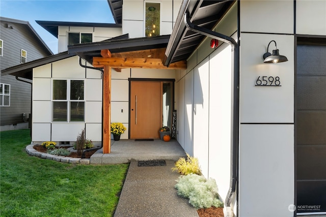 view of exterior entry with a lawn