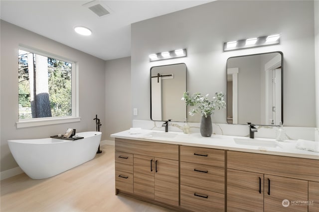 bathroom featuring vanity, a bathtub, and hardwood / wood-style flooring