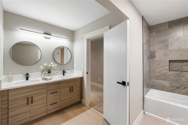 bathroom featuring hardwood / wood-style floors, vanity, and tiled shower / bath combo