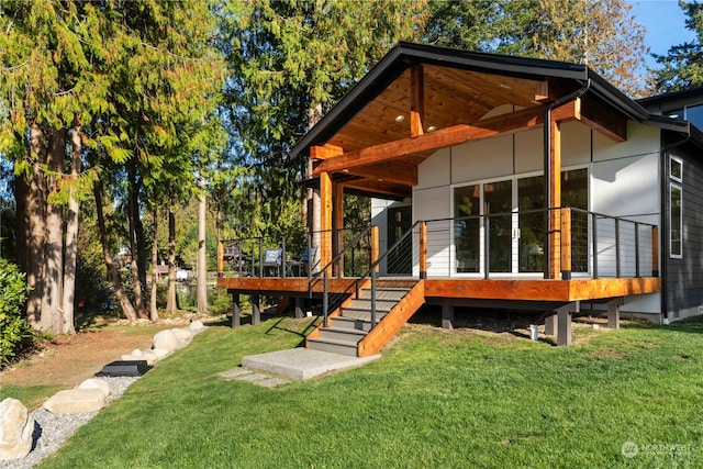 back of house with a deck and a lawn