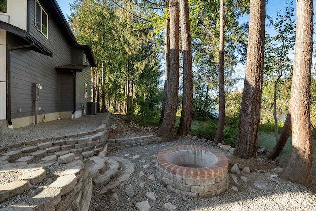 view of patio featuring cooling unit and a fire pit