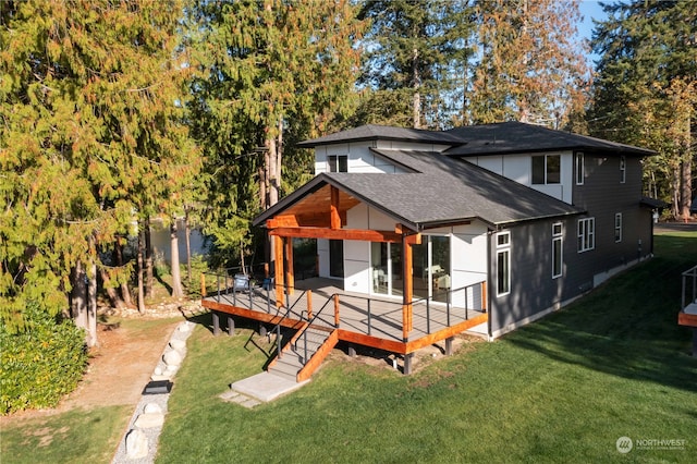 rear view of property featuring a wooden deck and a lawn