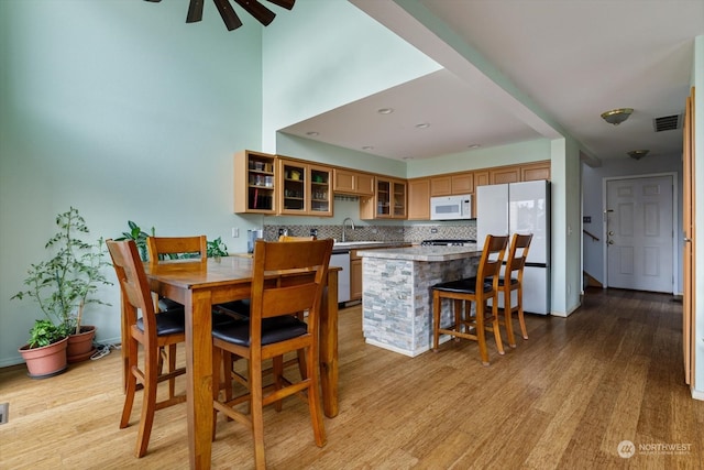 dining room featuring sink, ceiling fan, and light hardwood / wood-style floors