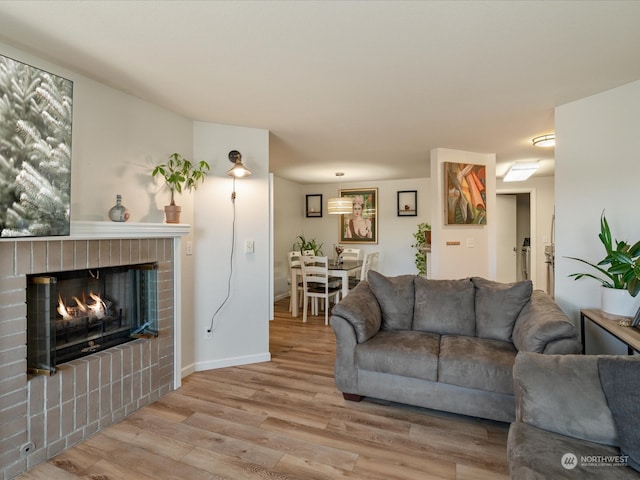 living room featuring hardwood / wood-style floors and a brick fireplace