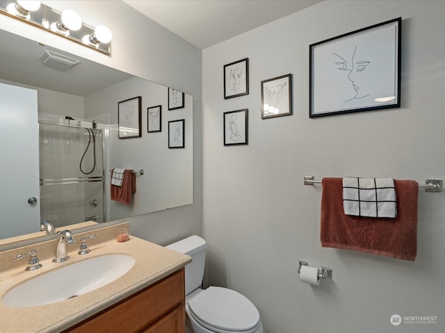 bathroom featuring walk in shower, toilet, and vanity