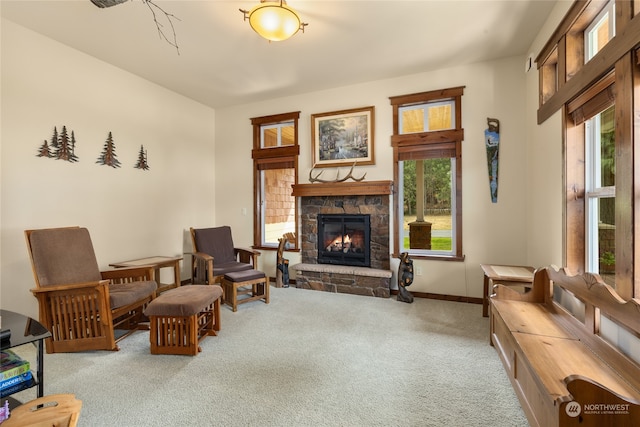 sitting room with light carpet and a stone fireplace