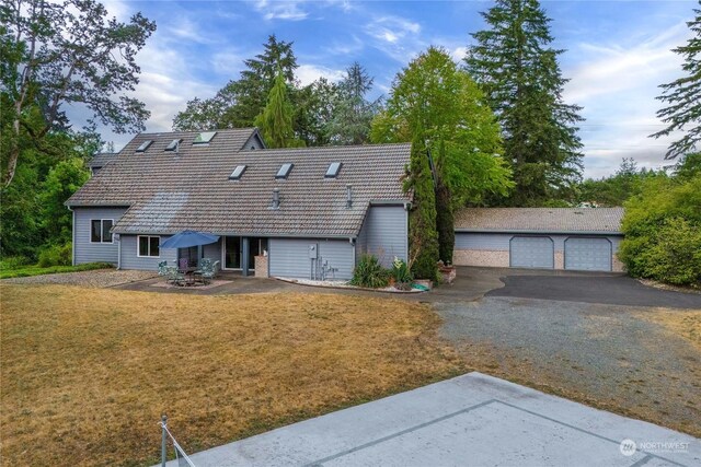 back of property with a lawn, a garage, and an outdoor structure