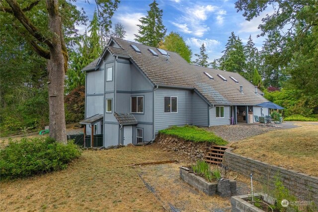 back of property with a lawn and a patio