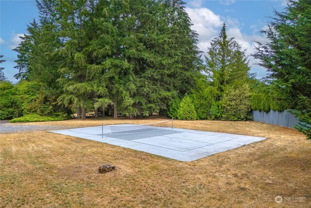 view of tennis court with a yard