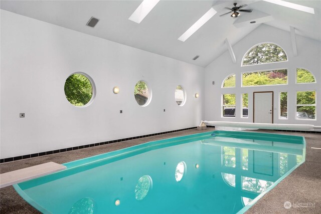 view of pool featuring a skylight, a jacuzzi, a diving board, and ceiling fan