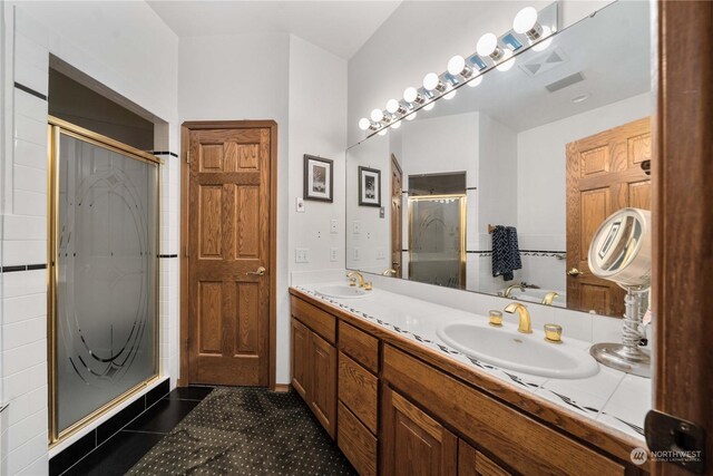 bathroom featuring vanity, an enclosed shower, and tile patterned flooring