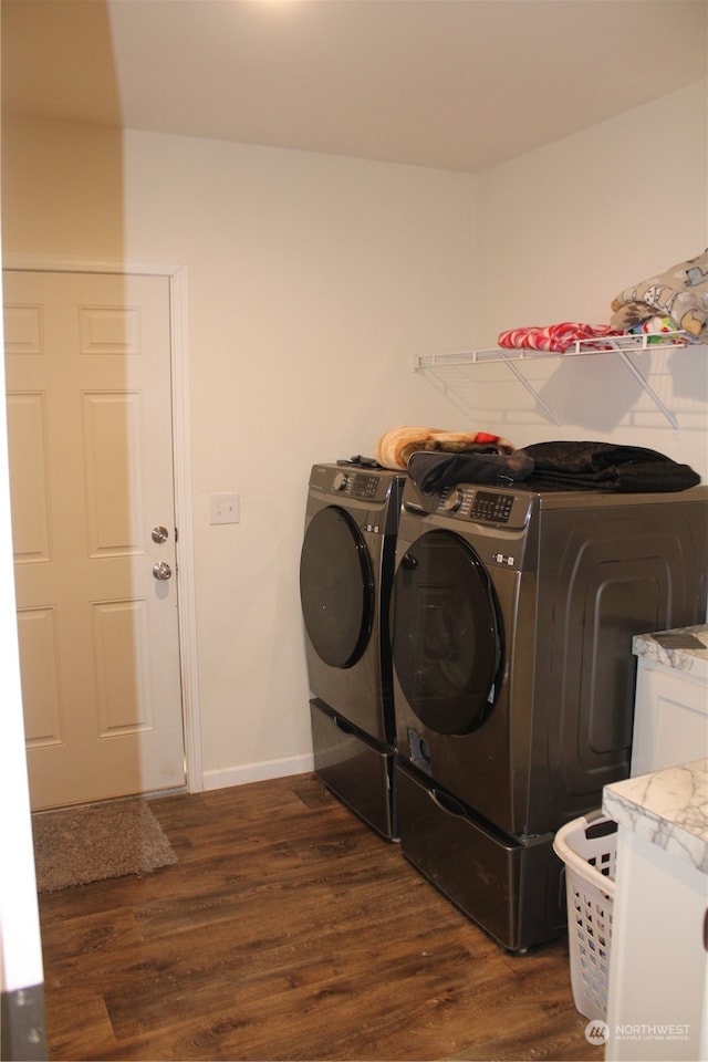 laundry room with dark hardwood / wood-style floors and washing machine and clothes dryer