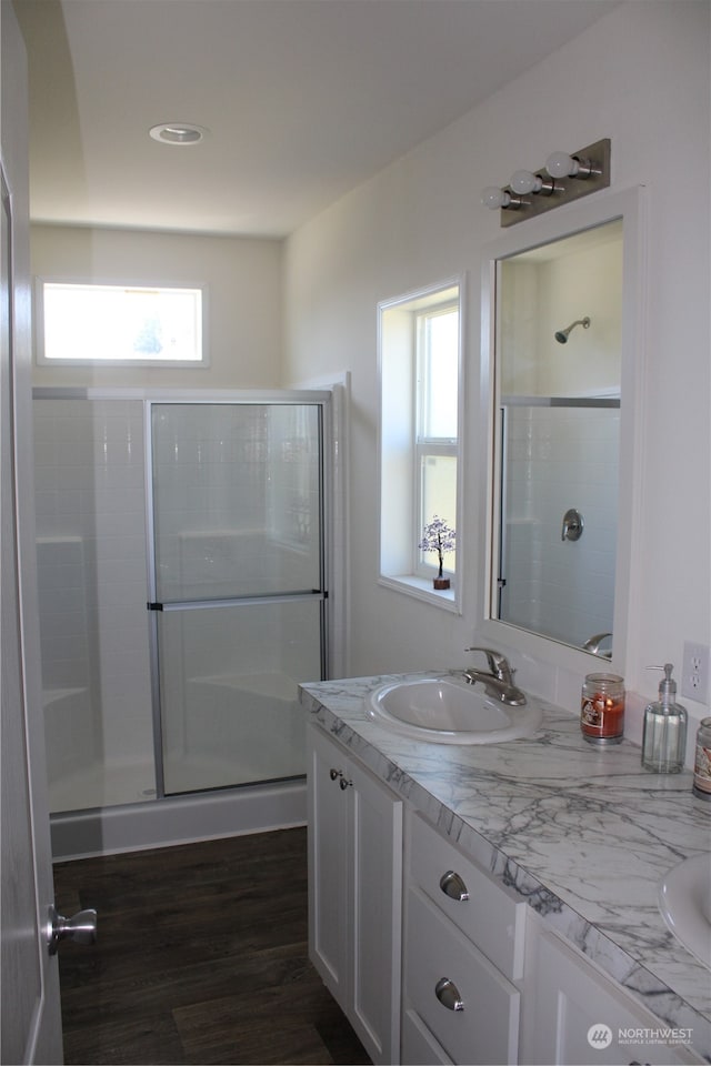 bathroom with vanity, hardwood / wood-style flooring, and a shower with shower door