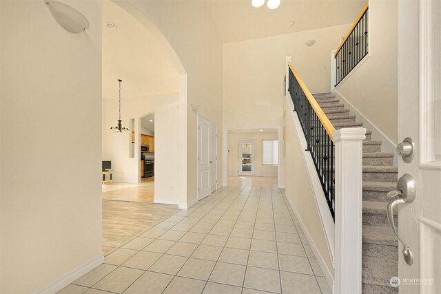 stairway with hardwood / wood-style floors and high vaulted ceiling